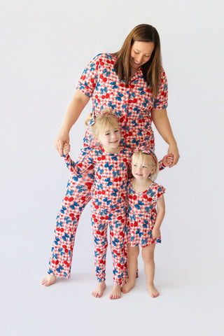 Woman and two children wearing matching red, white and blue cherry and star-patterned flare pajama sets.