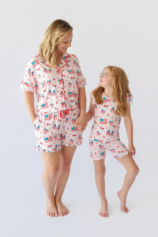 Woman and child wearing matching pink short sets with red, white, and blue flag and bow print throughout.