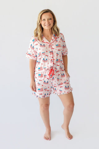 Women's short pajama set with red, white, and blue patriotic print including flags, bows, and stars throughout.