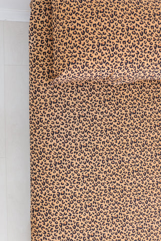 Twin sheet set with tan and black leopard print pattern displayed on a bed.
