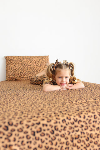 Twin sheet set with tan and black leopard print pattern, including fitted sheet, flat sheet, and pillowcase.
