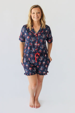 Women's short pajama set with navy background and red and white firework print, featuring button-front shirt and matching sho