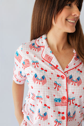 Women's short-sleeve pajama top with red and white gingham pattern, American flags, blue bows, and red flower prints througho