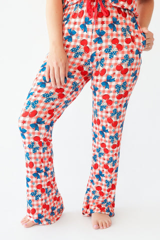 Women's flare pajama pants with red gingham, cherry, bow, and star print in red and blue.