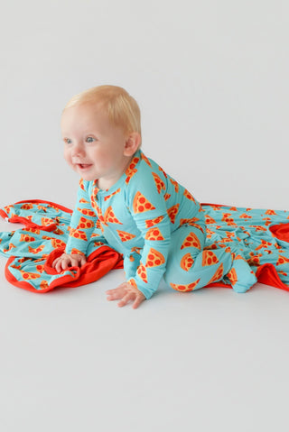 Toddler wearing a turquoise romper with red pizza slice print and red trim details.