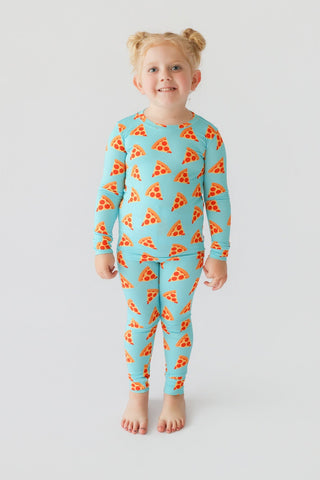 Child wearing turquoise long-sleeve top and matching pants with red pizza slice pattern throughout.