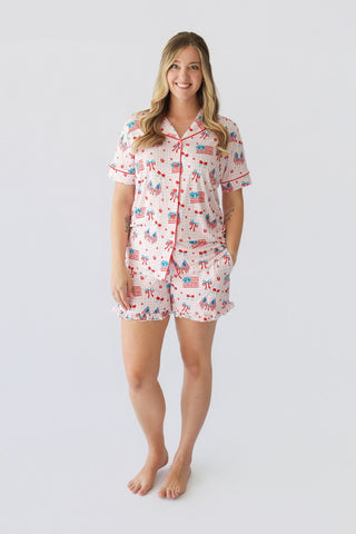 Women's short pajama set with red, white, and blue patriotic print featuring flags, bows, and cherries on white background.