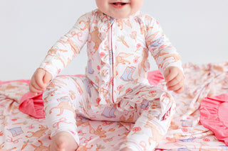Infant romper with long sleeves in cream with pink and orange boot and floral print, featuring ruffled trim and front zipper 