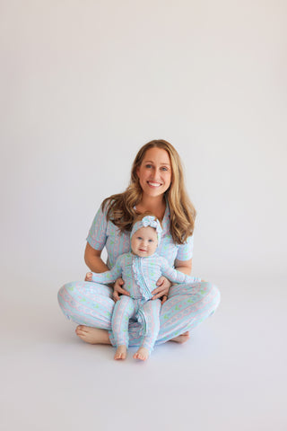Woman and infant wearing matching blue, pink, and green patterned short-sleeve flare pajama sets with tulip design.