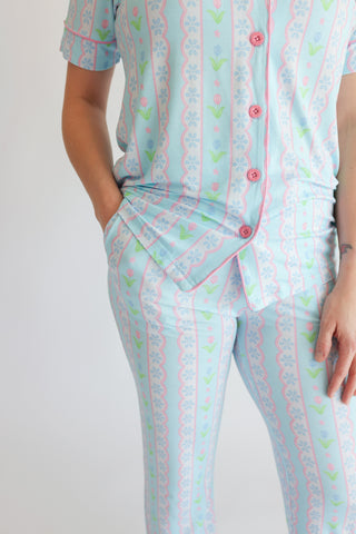 Women's pajama set with light blue base, pink button front, tulip and geometric floral print throughout, short sleeves, and f