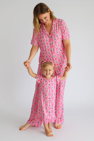 Woman and child wearing matching pink pajama sets with anchor and ribbon print pattern.