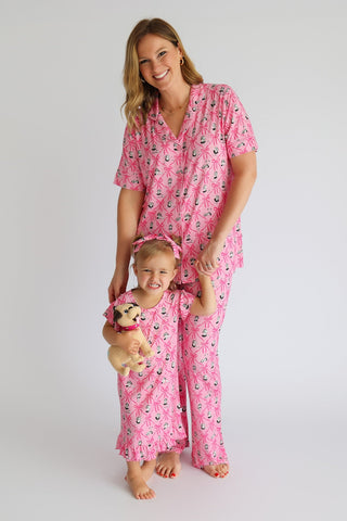 Woman and child wearing matching pink pajama sets with ribbon and lantern print pattern.