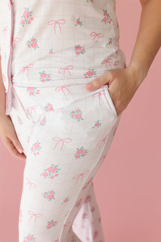 White quilted pajama set with pink bow and rose print, flare pants with side pockets.