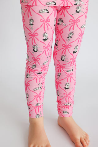 Pink leggings with pink ribbon bows and illustrated girls in black dresses on light skin-toned legs.