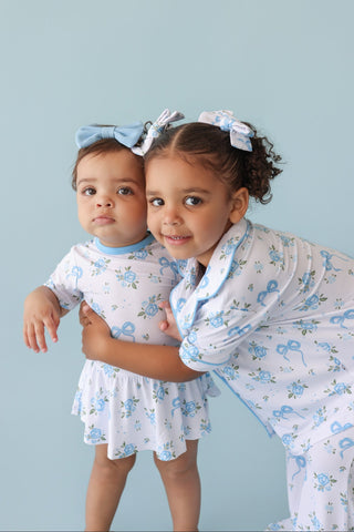 Two children wearing powder blue bow hair clips with floral details.