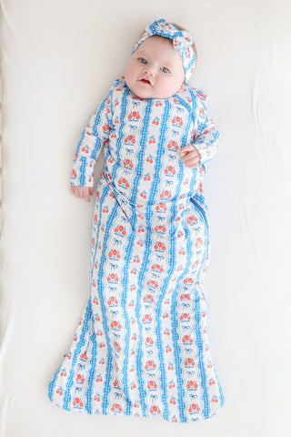 Infant sleep sack with blue and red floral print, matching headband, long sleeves, and tapered foot opening.