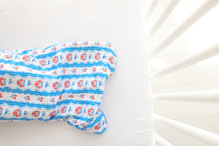 Quilted sleep sack with blue and white striped pattern and red floral print detail.