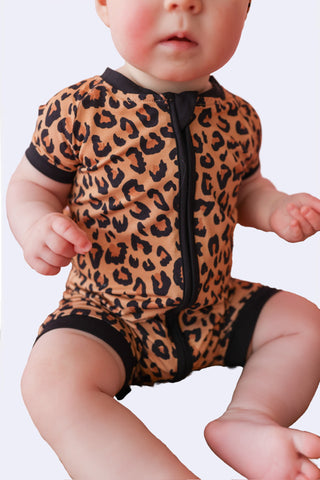 Infant romper with leopard print in caramel and black, featuring black trim and front zipper.