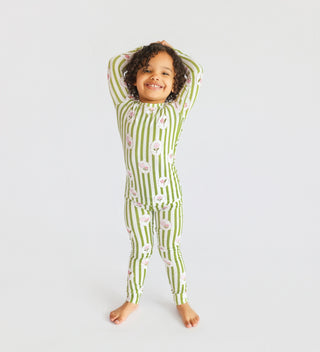 Child wearing green and white striped long-sleeve shirt and matching pants with pink floral print throughout.