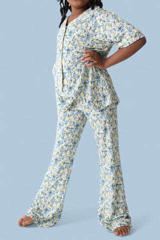 Girl's two-piece pajama set with yellow and blue floral toile print, short-sleeve button-up shirt and flare pants.