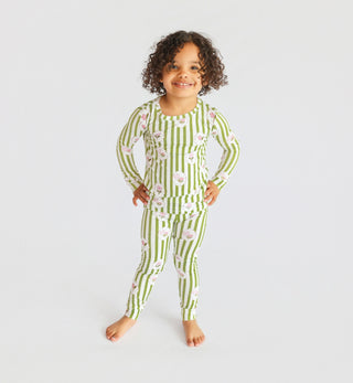 Child wearing green and white striped long-sleeve pajama set with pink floral pattern throughout.