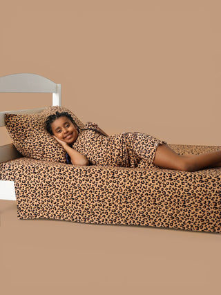 Twin sheet set with leopard print pattern in tan and black on a bed with matching pillowcase.